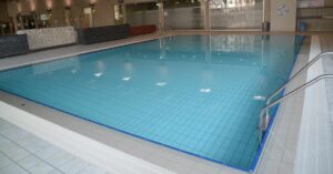Helles, sauberes Schwimmbecken mit blauer Fliesenoptik, ideal für Aquatherapie, Fitness und Schwimmunterricht in einem modernen Wellnesscenter.