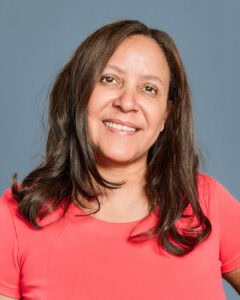 Entspannte Frau im roten Sporttop, lächelnd und zufrieden, auf Blau Hintergrund, gesunde Lebensweise, Fitness und Wellness, Aquafitness, Frau beim Wassersport, gesundes Leben, aktive Frauen, Gesundheit, Bewegung, Aquafit.