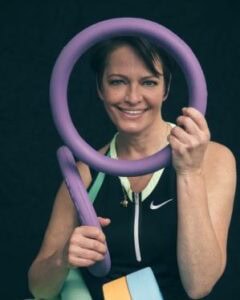 Aqua Fit Übung mit Fitnessexpertin, die in einem Schwimmbecken Wasserfitness-Training durchführt, um Kraft und Ausdauer zu verbessern.