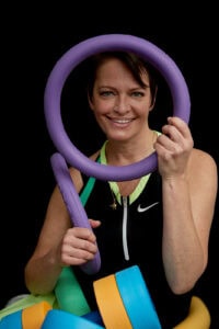 Entspannter älterer Frau beim Aqua-Fitness mit Flossen, Pool-Nudeln und Wasser-Workout-Ausrüstung.