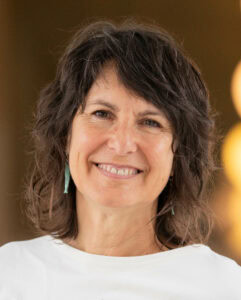 Fröhliche Frau mittig lächelnd, im Hintergrund warmes Licht, gesundes Lebensgefühl, Aqua Fit, Wellness, Fitness, Wassertraining, Aquafitness, aktive Lebensweise, Gesundheit, Sport.